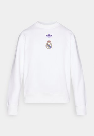Balt.Džemperis ar violets Adidas trefoil logotipu un Real Madrid emblēmu izšūtu uz krūtīm. Ribotas aproces un apakšmala. Kokvilnas maisījuma audums.