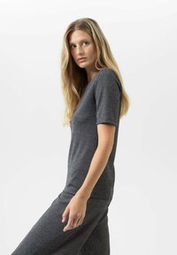 Donkergrijze, kortefrishe top gemaakt van textuurstof, met een eenvoudig, getailleerd ontwerp en een ronde hals.