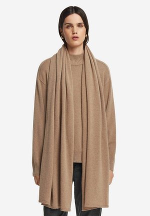 Beige cashmere sweater med ribbet rundhals, lange ærmer, og et matchende langt tørklæde draperet over skuldrene. Blød tekstur, minimalistisk design.
