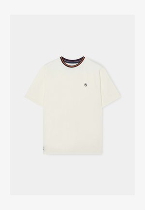 Camiseta color crema de mangas cortas, con un cuello de canalé que presenta detalles en burdeos, amarillo y morado, y un pequeño logo bordado en el pecho.