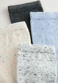 Vier Sockensets in verschiedenen Farben: gesprenkelt beige, grau, hellblau und dunkelgrau. Jede verfügt über einen gerippten Bund und ein strukturiertes Strickdesign.