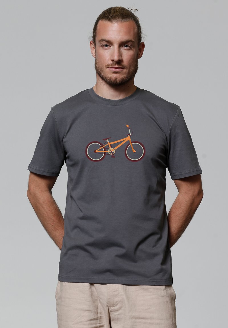 T-shirt en coton gris avec un design graphique d'un vélo orange avec des roues et des accents rouges, présenté sur un fond neutre.