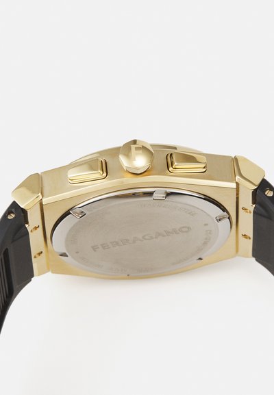 Gold-toned watch with a rectangular case, rubber strap, round crown, and dual pushers. Back displays brand engraving and stainless steel finish.