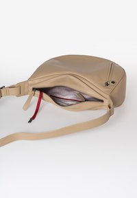 Beige Leder Umhängetasche mit runder Form, Reißverschluss-Hauptfach und einem roten Stoffakzent innen. Glatte Textur und verstellbarer Trageriemen.
