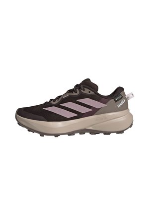 Czarno-beżowy but do biegania trailowego Adidas Terrex z różowymi paskami i grubą podeszwą, zaprojektowany do użytku na świeżym powietrzu.