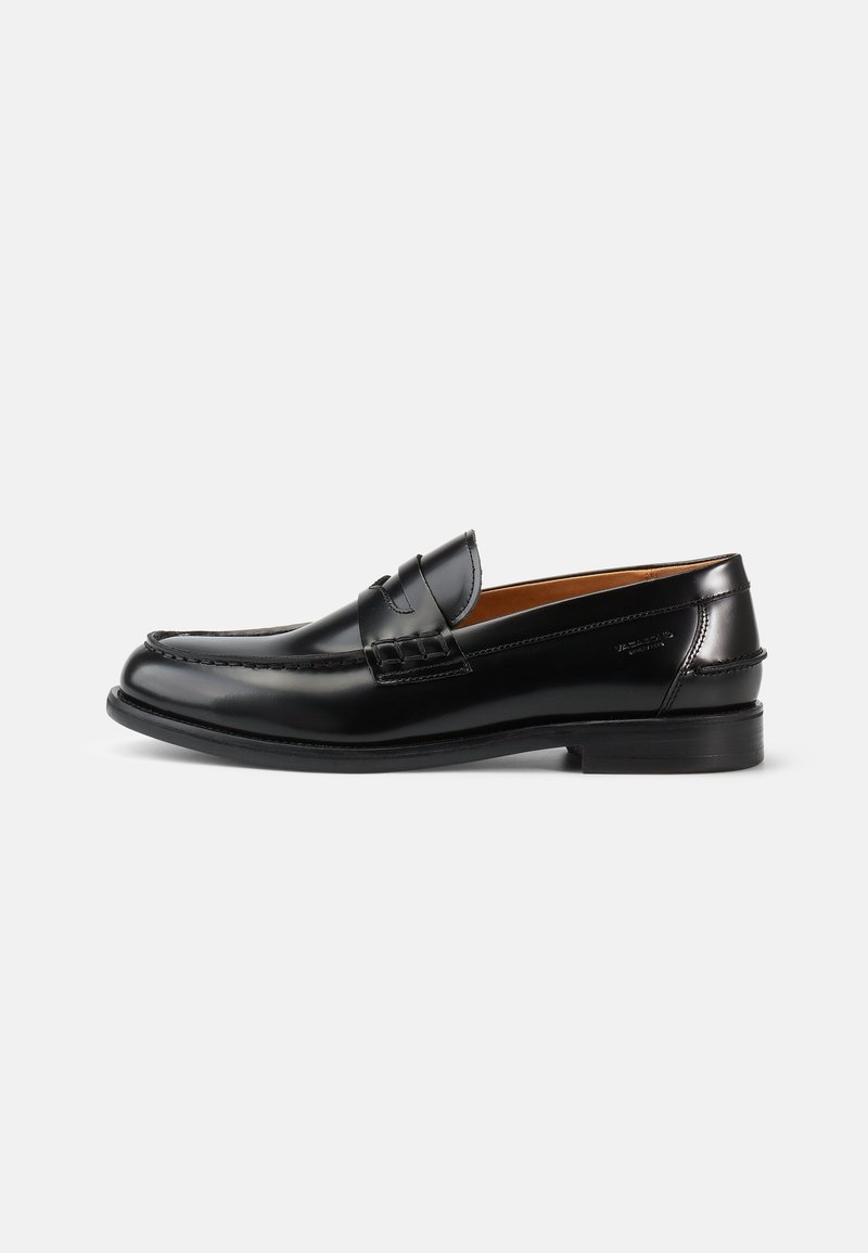 Mustad mustad nahast loafers, millel on sile viimistlus, ümar varvas ja dekoratiivne õmblus peal. Madal kann, mis omab klassikalist profiili.