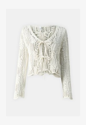 Crochet-style, cropped cardigan in cream. Features long sleeves, a deep V-neck, and adjustable tie closure at the front. Textured fabric with open weave.