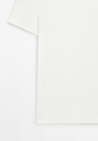 Bílý krátký rukáv tričko vyrobené z žebrované látky. Má klasický kulatý výstřih a bezšvový design. Měkká textura, minimalistický styl.