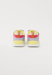 Daudzkrāsaini sporta apavi ar dzeltenu, purpura un rozā dizainu. Iezīmēts ar sietiņu un sintētiskajiem materiāliem, mīksto apkakli un baltu zoli.