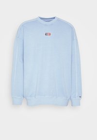 Světle modrý sweatshirt s kulatým výstřihem a dlouhými rukávy, se žebrovanými manžetami a lemem, a malou nášivkou s logem "Tommy" umístěnou na středu hrudi.