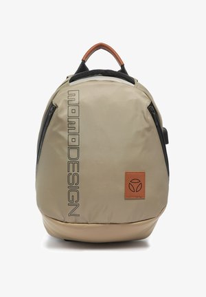 Zaino beige Momodesign con logo verticale nero, manico in pelle marrone, toppa frontale in pelle e tasche laterali con cerniera.