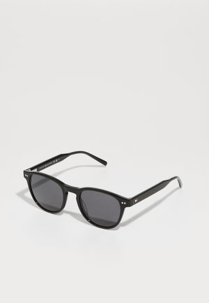 Black sunglasses with dark lenses, square frame, and textured finish. Features small silver accents and a logo on the temple.
