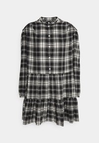 Rutig klänning i svart och vitt, gjord av vävt tyg, med krage, knäppning, långa ärmar och en tuffad volangkant.
