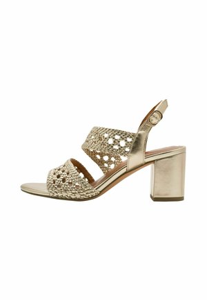 Sandali con tacco dorati con tomaia intrecciata e motivi traforati, punta aperta, cinturino regolabile alla caviglia e tacco a blocco.