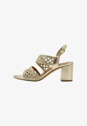 Sandali con tacco dorati con tomaia intrecciata e motivi traforati, punta aperta, cinturino regolabile alla caviglia e tacco a blocco.