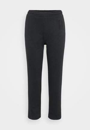 Pantalones de chándal negros con cintura elástica, forma ajustada y un sutil detalle de logo en la pierna izquierda. Hechos de una tela suave y lisa.