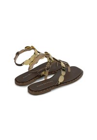 Sandali piatti marroni con accenti decorativi in oro e metallici, caratterizzati da cinturini testurizzati, una soletta imbottita e un bordo con borchie.