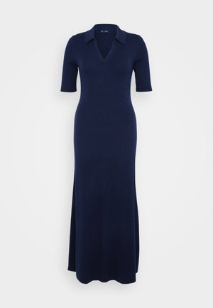 Vestido maxi de punto en azul marino oscuro con escote en V y mangas cortas. Presenta una textura acanalada y una abertura lateral para mayor facilidad de movimiento.