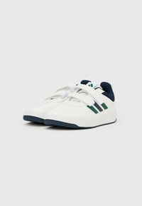 Baltos sportinės bateliai su dviem lipniomis juostelėmis, žaliomis ir tamsiai mėlynomis detalėmis, tekstūruotomis paviršių struktūromis ir suapvalintų noselių dizainu.