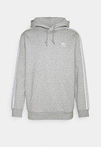 Sudadera Adidas de color gris claro con bolsillo frontal, detalles en blanco de tres rayas a lo largo de las mangas, capucha con cordón y pequeño logo de Adidas en el pecho.