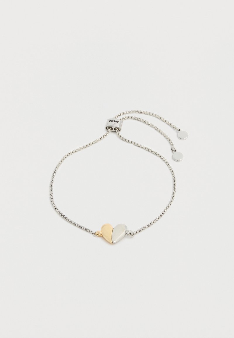 Ασημένιο ρυθμιζόμενο βραχιόλι αλυσίδας με δίχρωμο μενταγιόν καρδιάς—η μία πλευρά χρυσή, η άλλη ασημένια—σε λευκό φόντο.