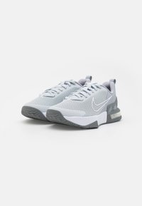 Scarpe da ginnastica grigio chiaro con tomaia in rete, accenti bianchi, collare imbottito e suola in gomma testurizzata progettata per la trazione.