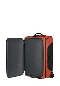 Red and black wheeled suitcase with a textured gray interior, featuring a dual compartment and a top carry handle.