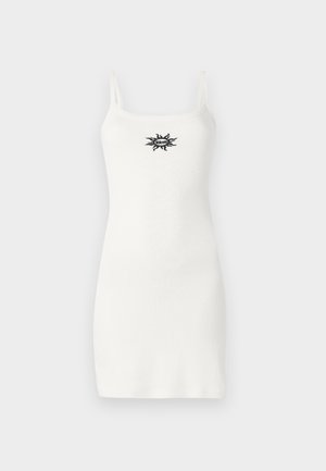 Balta maža suknelė be rankovių, su plonomis petnešomis, prigludusio silueto ir maža juoda grafika ant krūtinės, pagaminta iš lygaus medvilnės mišinio.