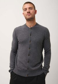 Šedý vlněný kardigan s kulatým výstřihem, sedm hnědých knoflíků vpředu, slim fit, žebrované manžety a lem, jemná textura.