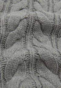 Tissu tricoté gris présentant un motif de câble texturé avec des points en relief, affichant un tissage doux, épais et confortable.