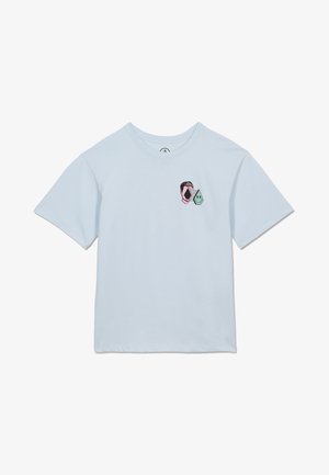 T-shirt bleu clair à manches courtes avec deux petites formes abstraites près de la poitrine : un contour de visage rose et une goutte souriante verte.