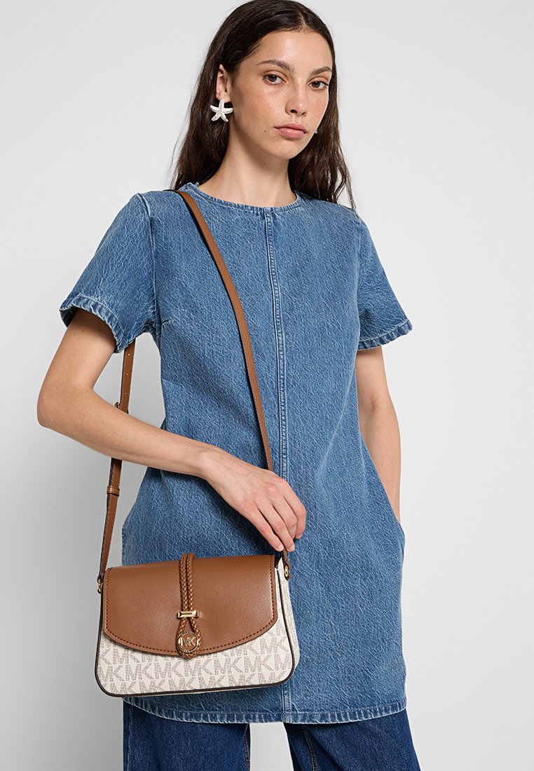 Sac bandoulière en cuir marron avec un rabat beige, des accents kaki et un motif de logo sur fond crème. Présente un détail de fermeture tressé.