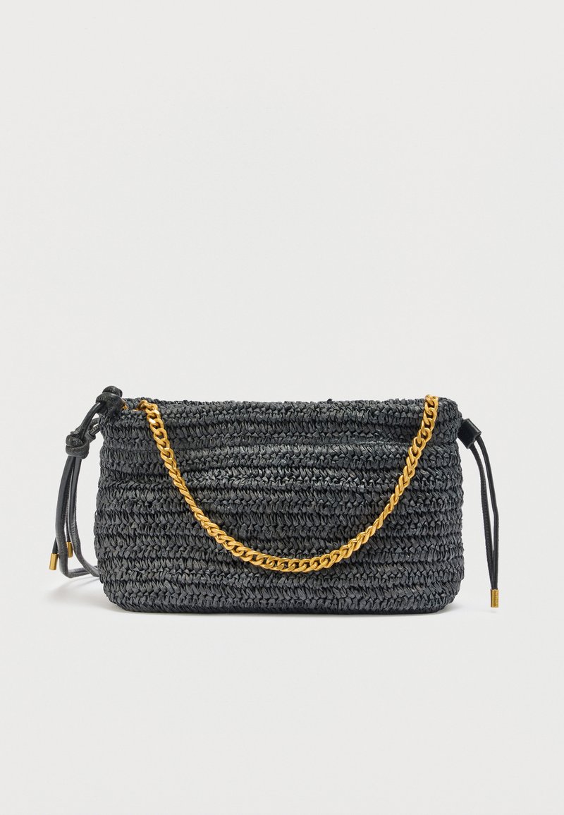 Μαύρη υφασμάτινη τσάντα χειρός με χρυσή αλυσίδα και μαύρα δερμάτινα κορδόνια σφίγγματος σε λευκό φόντο.