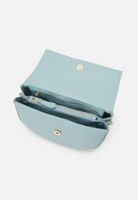 Světle modrá kožená kabelka s překlopnou klopou, zapínáním na druk, vnitřní kapsou na zip a hladkou texturou. Doplněná zlatým kováním.
