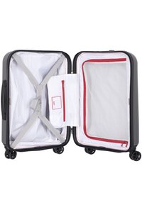 Valise rigide de couleur gris foncé avec un intérieur rayé. Comprend des poches en mesh, une poche zippée rouge et des sangles ajustables pour le contenu.