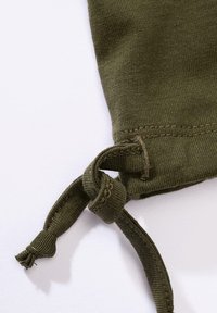 Tkanina oliwkowozielona związaną końcówką, charakteryzująca się gładką fakturą i luźnym supełkiem. Brzeg tkaniny ozdobiony jest delikatnym wzorem szwu.