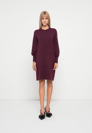 Robe tricotée en prune profond, avec de longues manches bouffantes et un col rond. Texture lisse, design à mi-mollet et style minimaliste.