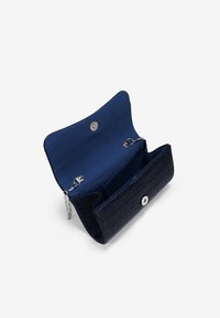 Bolso de mano texturizado en azul marino con cierre de presión plateado y asa de cadena. El interior cuenta con dos compartimentos para una mejor organización.