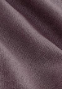 Struktureret stof i en blød mauve farve med et subtilt vævemønster. Materialet fremstår glat med en let glans.