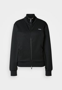 Black jacket with high collar, zip front, and two side pockets. Smooth fabric with ribbed cuffs and subtle logo detail on chest.