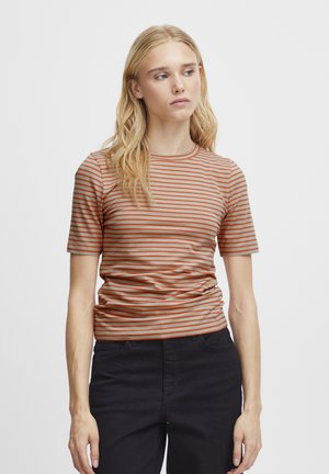 T-shirt à rayures à manches courtes en beige et orange. Design ajusté avec un col rond et une texture douce et lisse. Associé à un pantalon foncé.