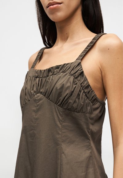 Σκούρο ελιά πράσινο φόρεμα με εφαρμοστή μπούστο, πιέτες κατά μήκος του ντεκολτέ και λεπτές τιράντες. Ομαλό, ελαφρύ ύφασμα με απαλή υφή.