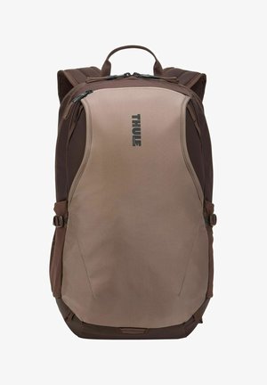 Mochila Thule marrón y beige con asa superior, correas de hombro acolchadas, compartimentos delanteros con cremallera y correas laterales de ajuste.
