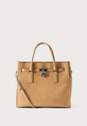 Tan leather handbag with double handles, a detachable shoulder strap with chain detail, and a central silver lock clasp.