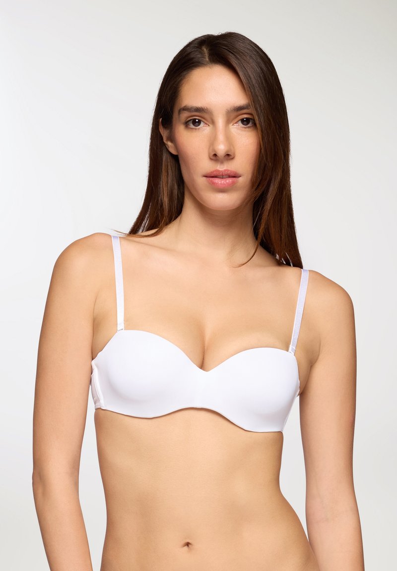 Reggiseno bianco imbottito con tessuto liscio, supporto con ferretto e spalline sottili e regolabili; le coppe strutturate creano una forma arrotondata.