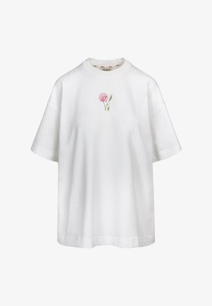 Biała oversize koszulka z krótkimi rękawami i małym różowym kwiatuszkiem umieszczonym na środku poniżej dekoltu.