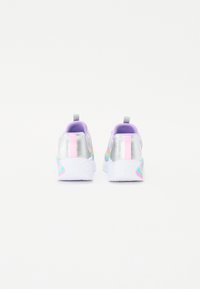 Zapatillas deportivas con una parte superior plateada brillante, acentos morados, suelas blancas y una franja rosa. Tacón texturizado y patrón multicolor en el lateral.