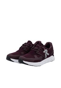Scarpe sportive color marrone con tomaia in mesh traspirante, suola bianca e dettaglio del logo grigio. Presentano una chiusura con lacci e accenti testurizzati.