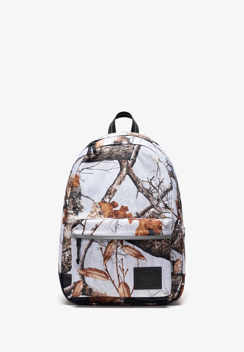 Sac à dos avec un fond blanc et un motif camouflage de feuilles d'automne marron et grises ainsi que des branches d'arbre, poche avant zippée et anse noire.
