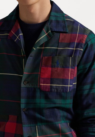 Geruite shirt in groen, marineblauw en rode tinten, met een borstzak en zwarte knopen, gemaakt van lichtgewicht stof met een gladde текстuur.